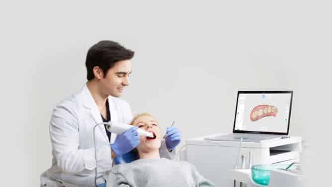 dentist using intraoral scanner to take impression of patient